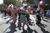 People dressed in World War II era clothes dance in the street during celebrations of the liberation of Paris from Nazi occupation 75 years ago, in Paris, Sunday, Aug. 25, 2019. Enthusiasts are retracing the entry of French and U.S. tanks into the city on Aug. 25, 1944. (AP Photo/David Vincent)