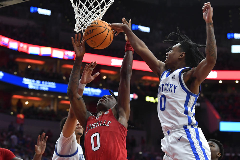 Kentucky guard Rob Dillingham, right, blocks the shot of Louisville guard Mike James during the second half of an NCAA college basketball game in Louisville, Ky., Thursday, Dec. 21, 2023. Kentucky won 95-76. (AP Photo/Timothy D. Easley)