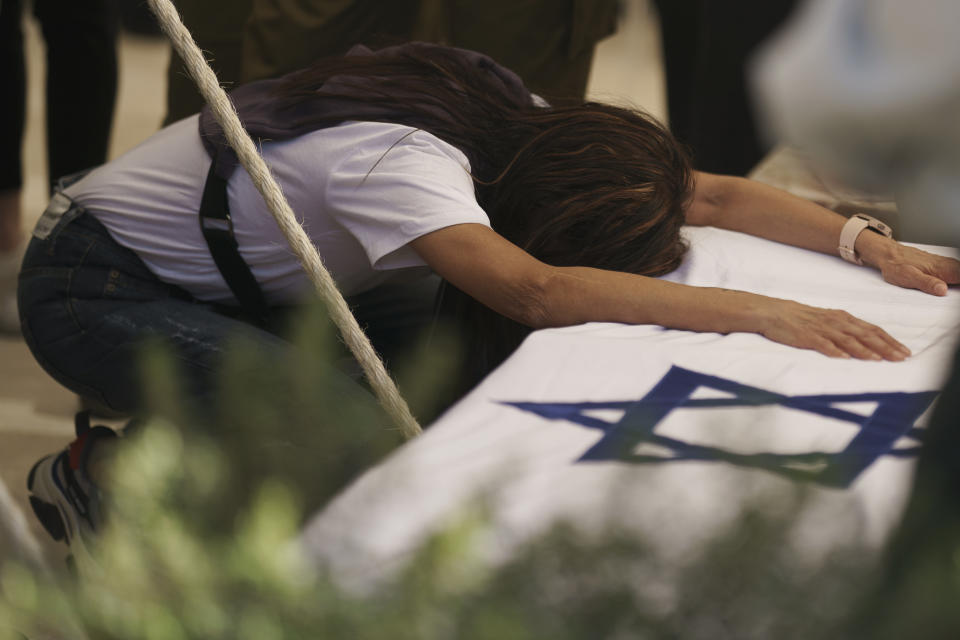 Mother of Israeli Col. Asaf Hamami mourns during his funeral at the Kiryat Shaul military cemetery, in Tel Aviv, Israel, Monday, Dec. 4, 2023. Hamami, the commander of the Gaza Division's Southern Brigade, was killed on Oct. 7, in the unprecedented, multi-front attack on Israel by the militant group Hamas that rules Gaza. and his remains are being held in the Gaza Strip, the Israeli military said. (AP Photo/Leo Correa)