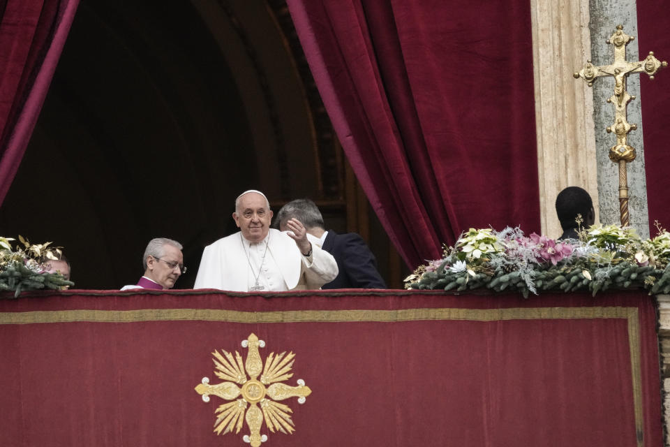 Pope Francis waves before delivering the Urbi et Orbi (Latin for 'to the city and to the world' ) Christmas' day blessing from the main balcony of St. Peter's Basilica at the Vatican, Monday Dec. 25, 2023. (AP Photo/Gregorio Borgia)