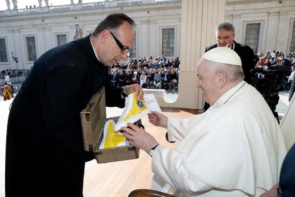 Father Jim Sichko gives a pair of customized shoes to Pope Francis. The shoes were designed by Lexington artist Billy Hobbs.