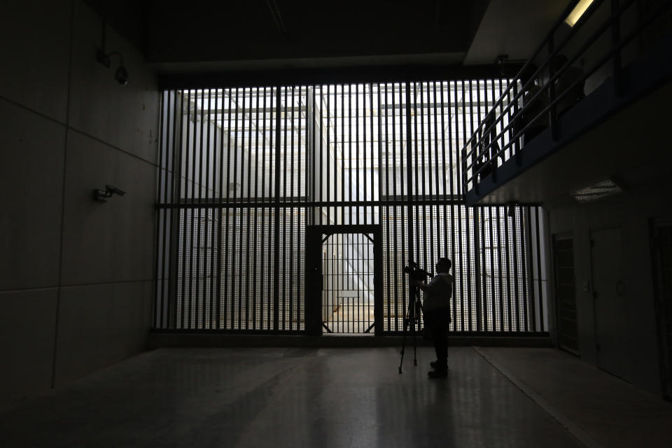 In this Saturday, March 16, 2019 photo, a journalist films the now closed Laguna del Toro maximum security facility during a media tour of the former Islas Marias penal colony located off Mexico's Pacific coast. Bars and cells were limited to the maximum security facility because the surrounding ocean effectively prevented escape. (AP Photo/Rebecca Blackwell)