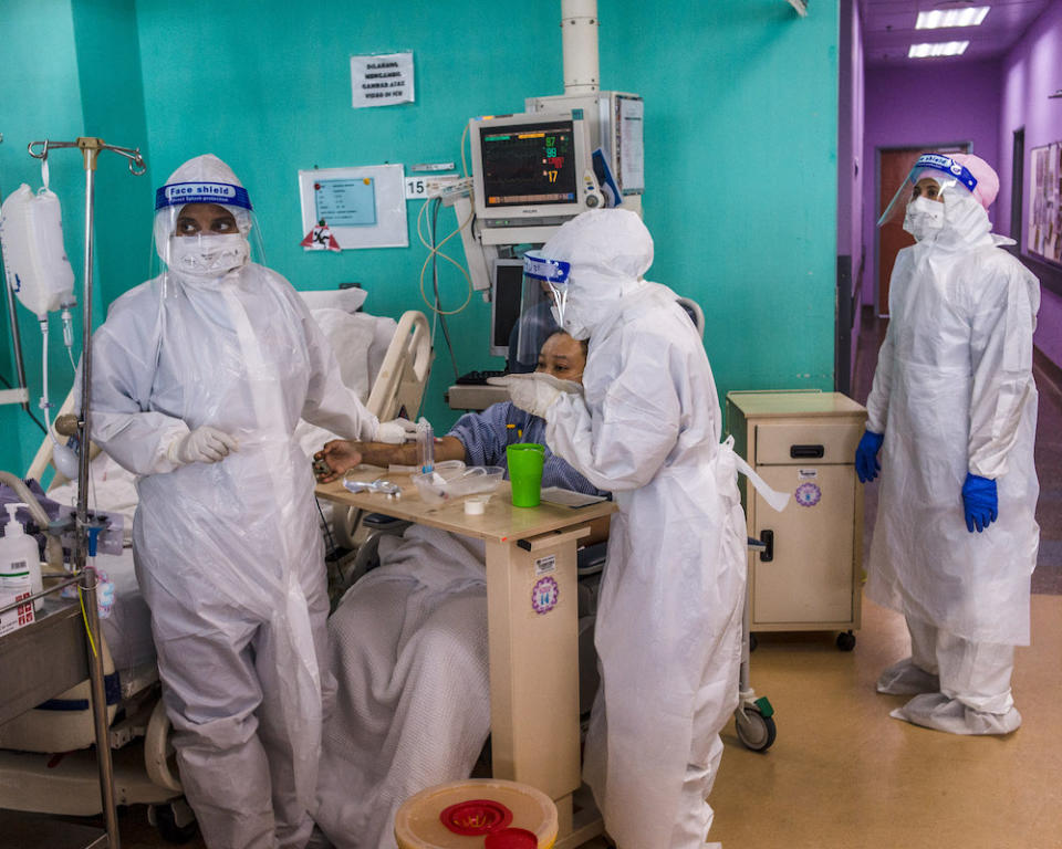 Health workers wearing PPE perform routine procedures on Covid-19 patients who have recovered and are not intubated in the ICU at Serdang Hospital. — Picture by Shafwan Zaidon