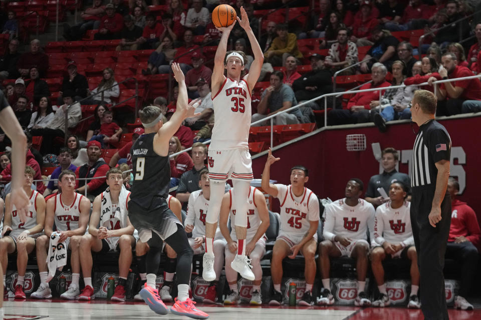 Utah center Branden Carlson (35) shoots as Washington guard Paul Mulcahy (9) during the second half of an NCAA college basketball game, Sunday, Dec. 31, 2023, in Salt Lake City. (AP Photo/Rick Bowmer)