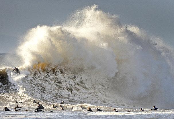 Surfers enjoy the large waves at the entrance to Santa Barbara, Calif., harbor Saturday morning, Jan. 21, 2017. A winter storm is bringing much higher than usual waves to the area. (Mike Eliason/Santa Barbara County Fire Department via AP)