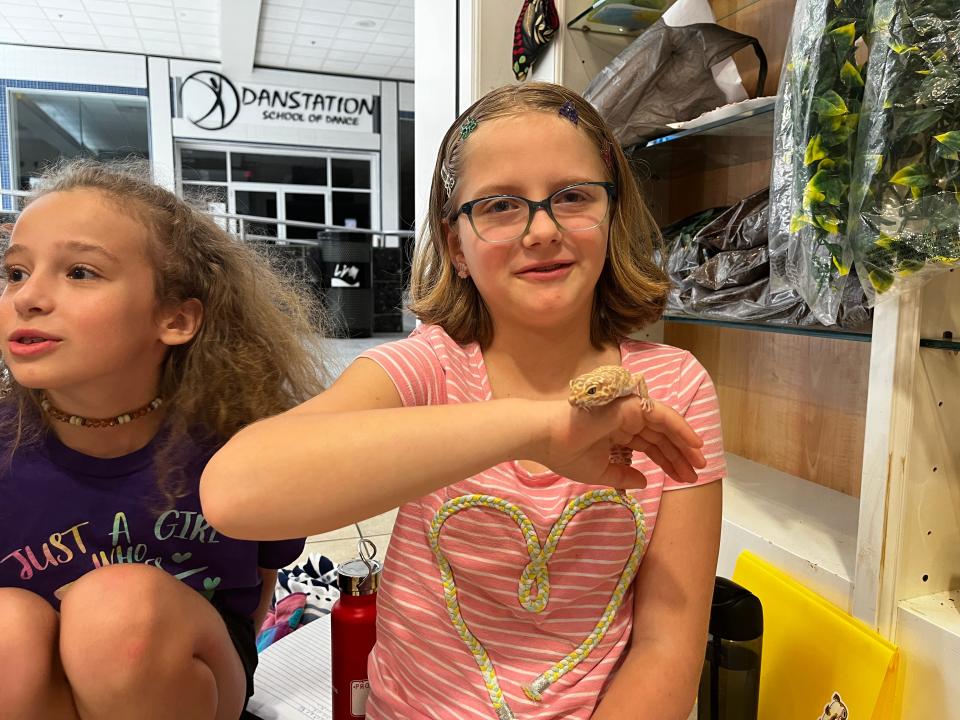 Abby Foltz (right)  is saving money to adopt Maggie Jane, the leopard gecko on her hand.