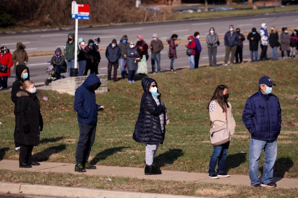 People wait in a long line for free Covid-19 at-home antigen rapid tests at a library in Silver Spring, Maryland, on Friday.