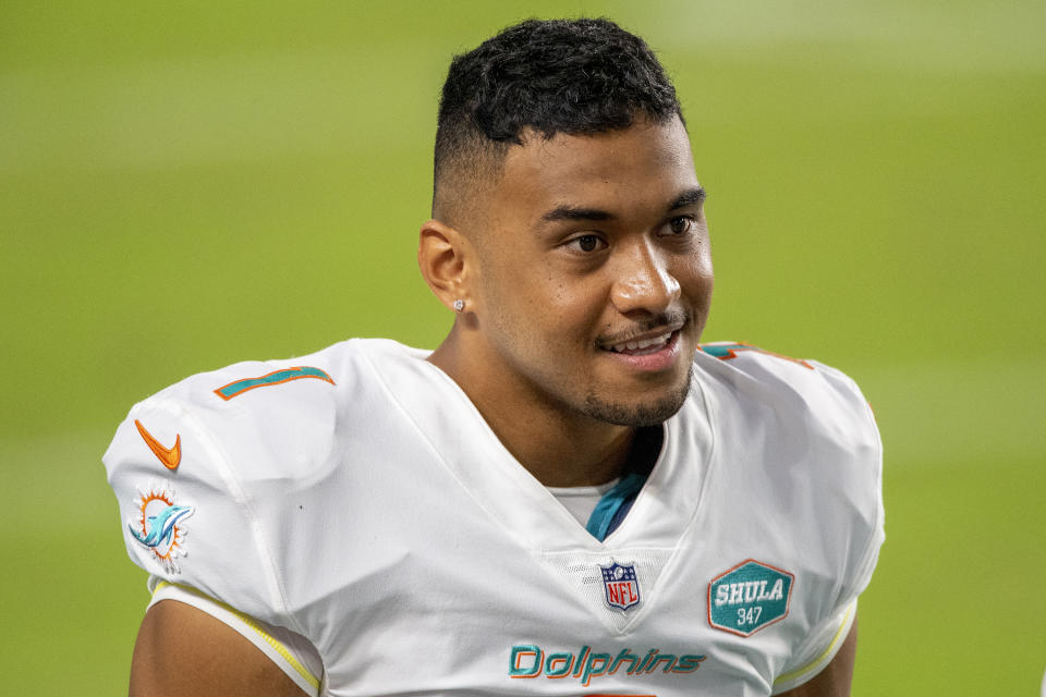 Miami Dolphins quarterback Tua Tagovailoa (1) smiles on the sidelines before playing for the first time against the New York Jets during an NFL football game, in Miami Gardens, Fla. Miami Dolphins coach Brian Flores says he regrets that his players found out about the team's switch to quarterback Tua Tagovailoa through social media rather than from him. And Flores says the decision to bench popular veteran Ryan Fitzpatrick was difficult.(AP Photo/Doug Murray)