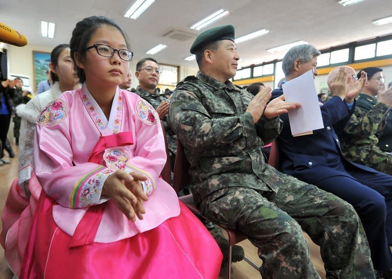 South Korean graduates wearing traditional dress sit next to military officers during a graduation ceremony for Taesungdong Elementary School at Taesungdong freedom village near the border village of Panmunjom in Paju on February 15, 2013. Six students graduated from the only school in this South Korean village sitting inside the demilitarized zone between North and South Korea