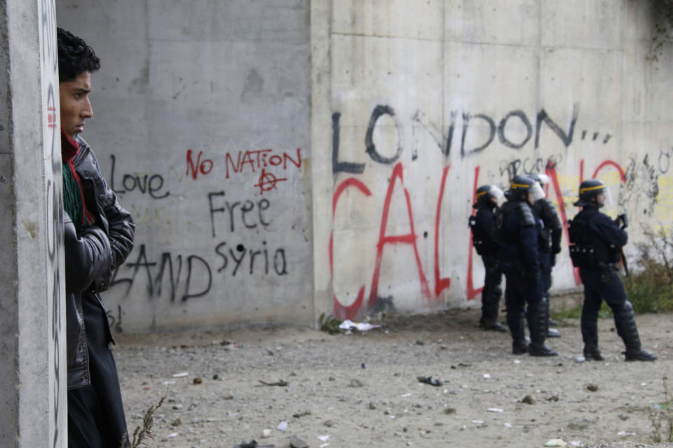 <p>A migrant watches as French riot police stand near during a protest near the area called the “jungle” where migrants live in Calais, France, Oct. 1, 2016. (Photo: Pascal Rossignol/Reuters)</p>