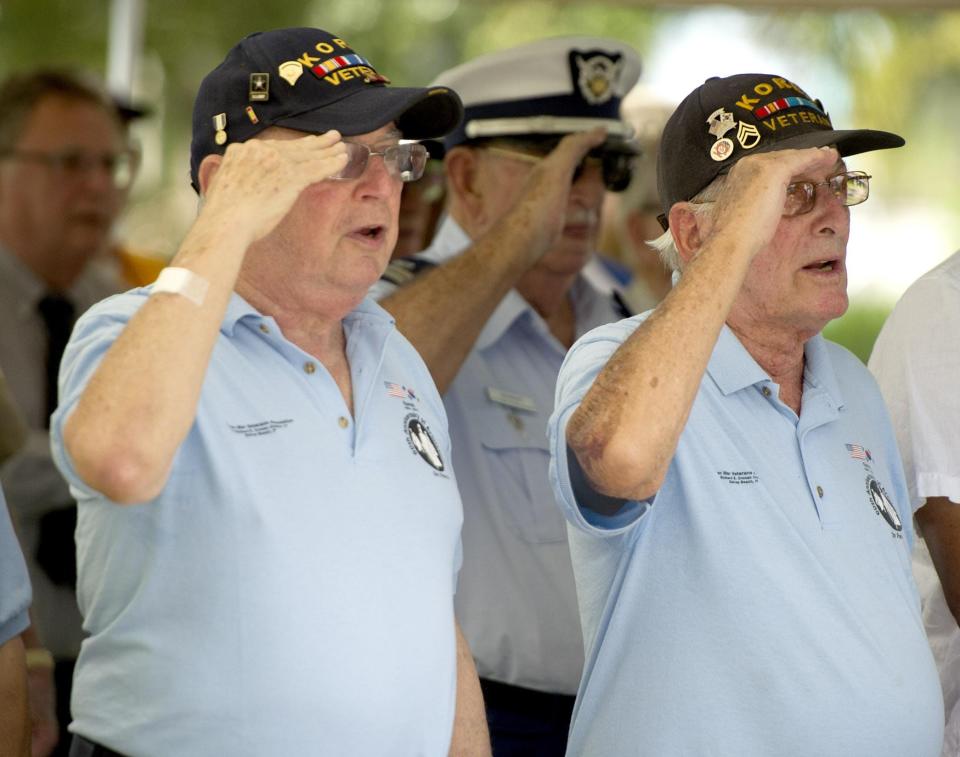 Army veteran Howard Garlin (left) participated in local veterans groups.  Here, with Shelly Evans, the Korean War veteran salutes at a 2017 service commemorating V-J Day, which ended World War II.