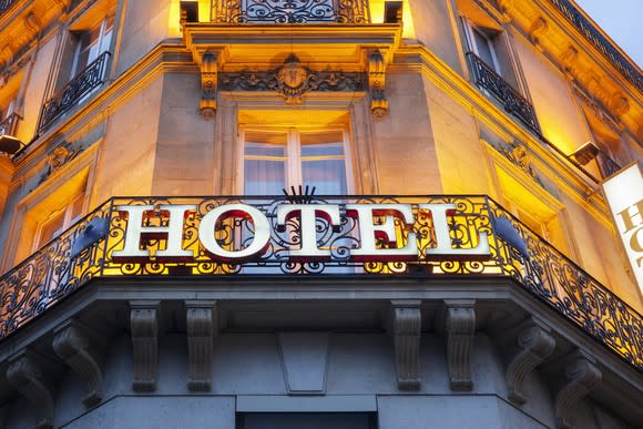 The facade of a hotel bathed in yellow light.