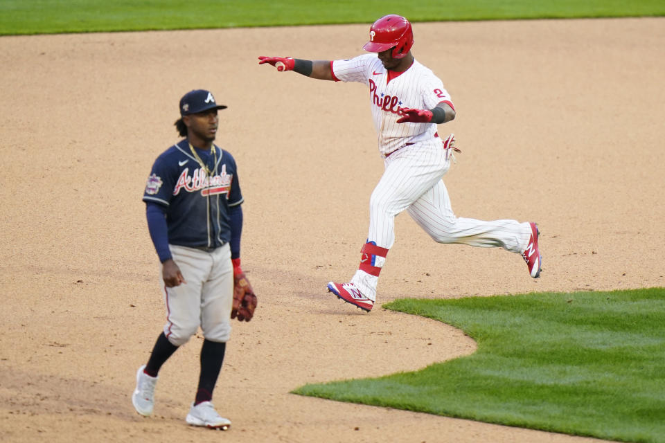 Philadelphia Phillies' Jean Segura, right, celebrates past Atlanta Braves second baseman Ozzie Albies after hitting a game-winning RBI-single during the 10th inning of an opening day baseball game, Thursday, April 1, 2021, in Philadelphia. (AP Photo/Matt Slocum)