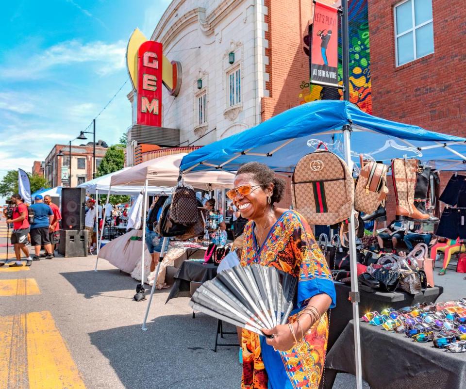 Leslie Shortey, a master life coach, paused to use her fan in the 90-degree heat on Vine Street during 816 Day. Roy Inman/Special to The Star