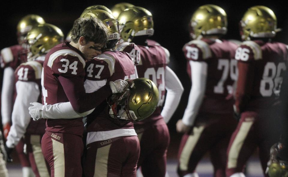 Watterson's Ben Gabrich and Tyler Lieu console one another following the Eagles' 33-28 loss to Bloom-Carroll in the Division III Regional Final game at DeSales on Nov. 18.