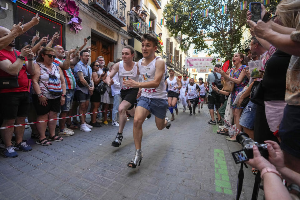 Participants compete during the Pride Week annual high heels race in the Chueca district, a popular area for the gay community in Madrid, Spain, Thursday, July 4, 2024. (AP Photo/Paul White)