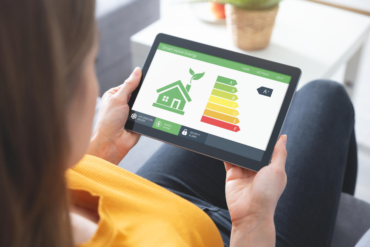 A woman looking at an energy efficiency app on a tablet screen