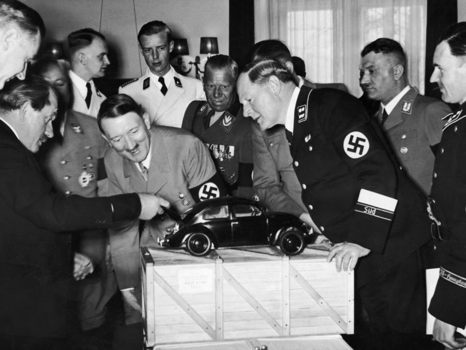 Nazi leader Adolf Hitler (1889 - 1945) admires a model of the Volkswagen car and is amused to find the engine in the boot. He is with the designer Ferdinand Porsche (left), and to the right are Korpsfuhrer Huehnlein, Dr Ley, Schmeer, and Werlin