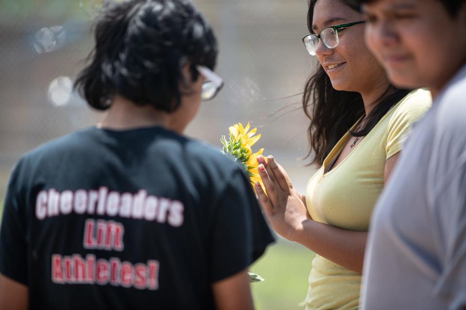 Alanya Vega, 13, touches a sunflower in a community garden, funded by Humana and built by the Boys & Girls Clubs of the Coastal Bend, on Thursday, June 9, 2022, in Corpus Christi, Texas.