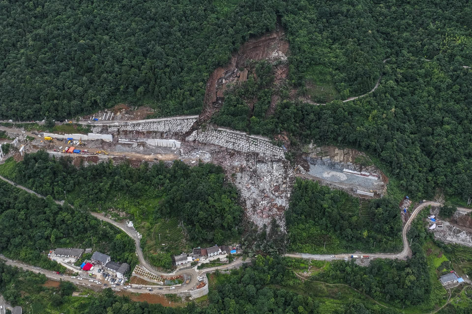 In this photo released by Xinhua News Agency, an aerial view shows rescuers conduct a search and rescue operation at a highway construction site hit by a landslide in Yueshan Village under Tujia Autonomous County of Wufeng in central China's Hubei Province Sunday, July 9, 2023. Rescuers were looking Monday for seven people missing in a landslide triggered by torrential rains while employers across much of China were ordered to limit outdoor work due to scorching temperatures as the country struggled with heat, flooding and drought. (Wu Zhizun/Xinhua via AP)