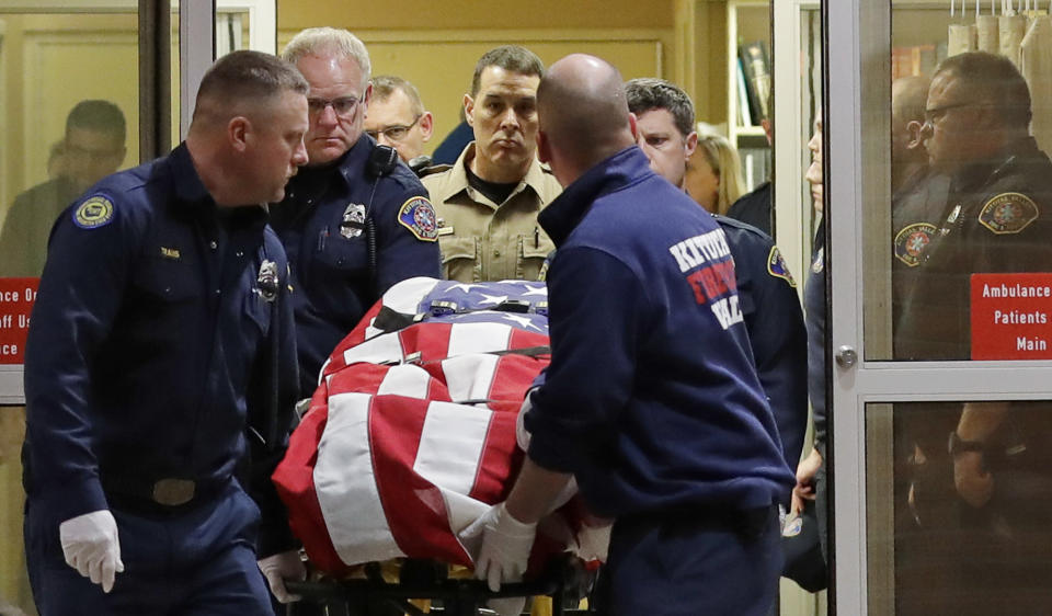 The body of a Kittitas County Sheriff's deputy is draped with a U.S. flag as it is carried out of Kittitas Valley Healthcare Hospital in the early morning hours of Wednesday, March 20, 2019, in Ellensburg, Wash. A sheriff's deputy was killed and a police officer was injured after an exchange of gunfire during an attempted traffic stop. (AP Photo/Ted S. Warren)