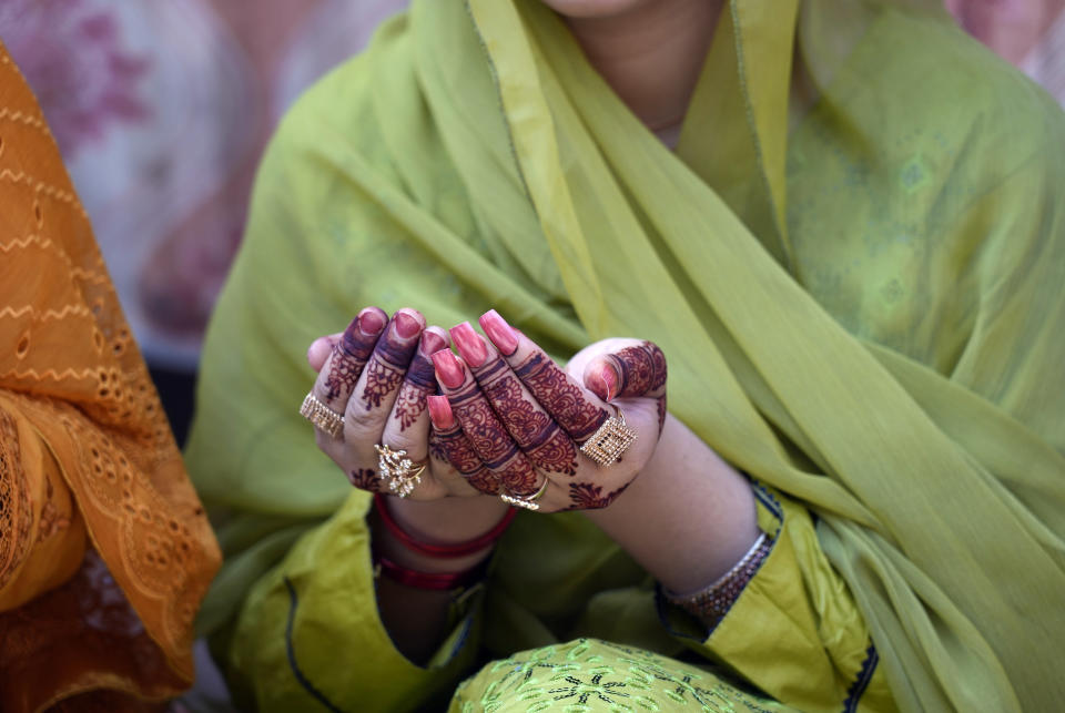 A woman has her hands painted with traditional henna as she attends Eid al-Adha prayers at historical Badshahi mosque in Lahore, Pakistan, Monday, June 17, 2024. Eid al-Adha or Feast of Sacrifice, the most important Islamic holiday, marks the willingness of the Prophet Ibrahim, Abraham to Christians and Jews, to sacrifice his son. During the holiday, which in most places lasts three days, Muslims slaughter goat, sheep or cattle, distribute part of the meat to the poor. (AP Photo/K.M. Chaudary)