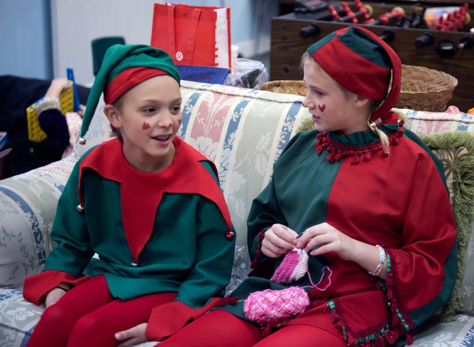 Dressed as yule log pages, Hillary Lamphere, 8, and Charlotte Ryan, 12, chat before Saturday's festival.