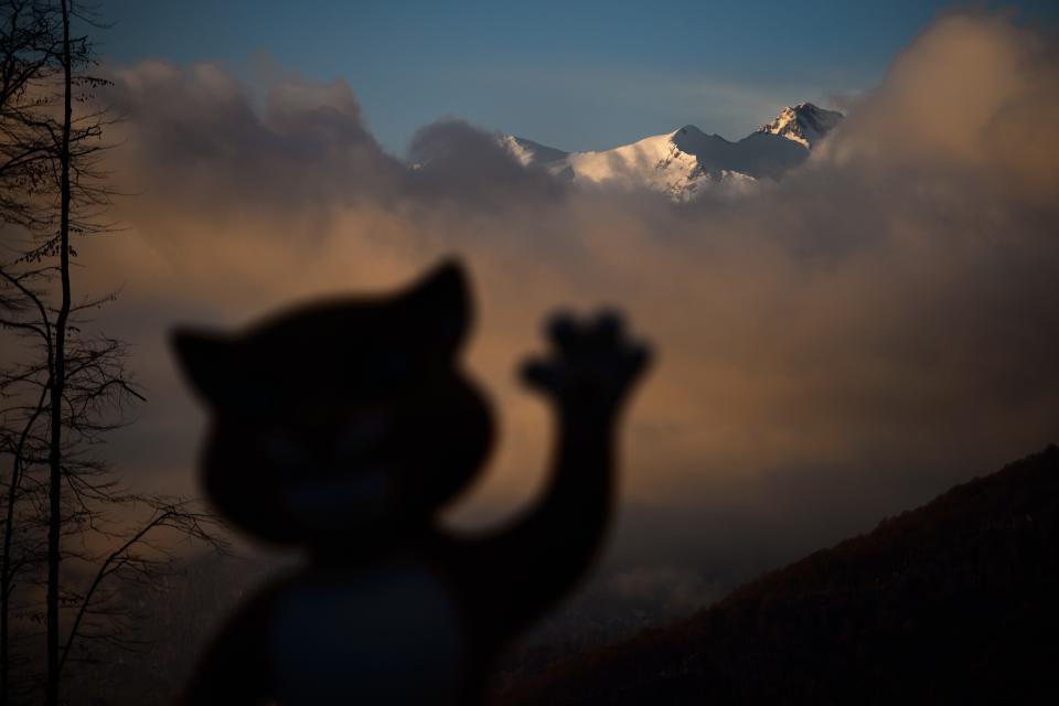 A mascot of Sochi Winter Olympics is seen in silhouette with mountains at sunset at the Mountain athletes village during the Sochi Winter Olympics on February 11, 2014. 