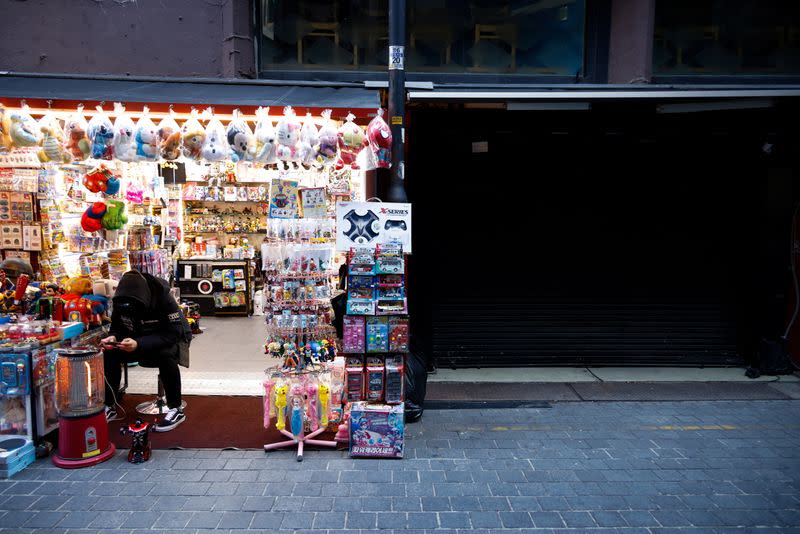 A shopkeeper waits for customers at an empty shopping district amid the coronavirus disease (COVID-19) pandemic in Seoul