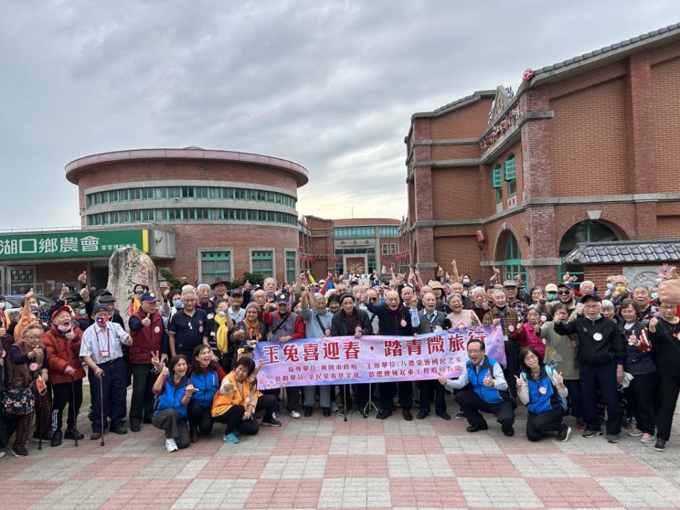 八德榮家萬歲團至湖口好客園區出遊，看到湖口老街景緻開心拍合照。（記者彭新茹攝)