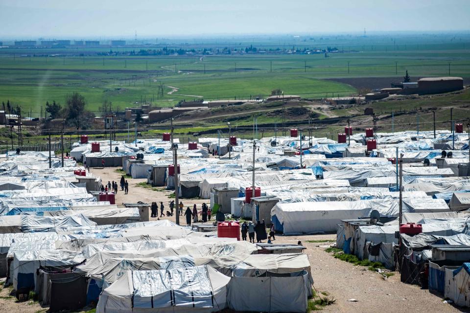 Women and children walk at Camp Roj, where relatives of people suspected of belonging to Isis are held (AFP via Getty Images)