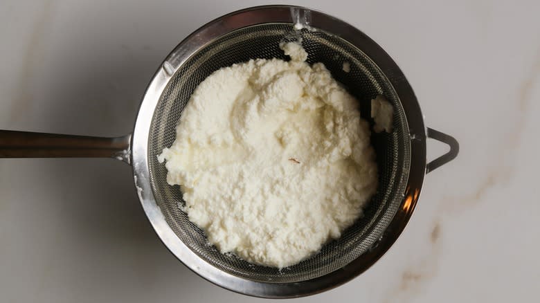 Ricotta draining in sieve