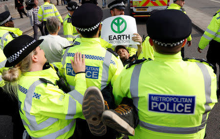 Police officers detain a climate change activist at Waterloo Bridge during the Extinction Rebellion protest in London, Britain April 18, 2019. REUTERS/Peter Nicholls