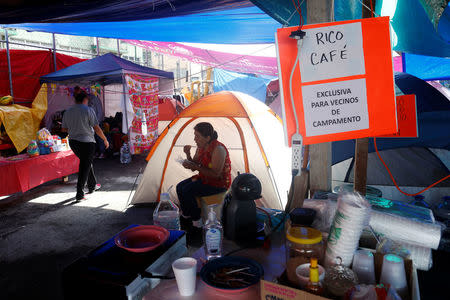 A resident eats in a provincial campsite after her house was affected by the the earthquake in Mexico City, Mexico September 25, 2017. REUTERS/Carlos Jasso