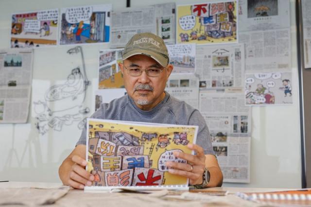 Cartoonist Wong Kei-kwan, who uses the pen name Zunzi, poses for photos after his comic strip has been scrapped from the local newspaper Ming Pao in Hong Kong