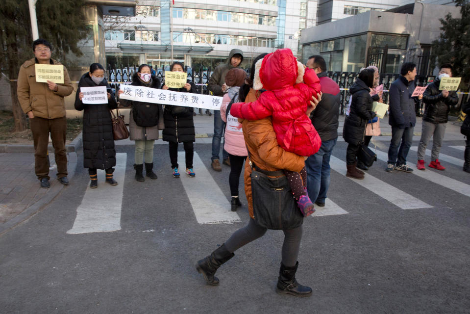 Auf diesem Bild aus dem Jahr 2016 protestieren Eltern von Mehrkindfamilien vor dem Gebäude der Staatlichen Kommission für Familienplanung gegen die Strafen, die gegen sie verhängt wurden. (Bild: AP Photo/Ng Han Guan)