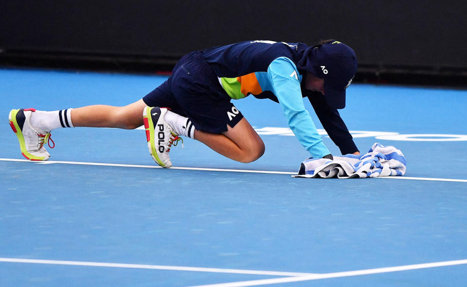 A ball boys, pictured here mopping up the court before the women's singles match between Barbora Krejcikova and Clara Burel.