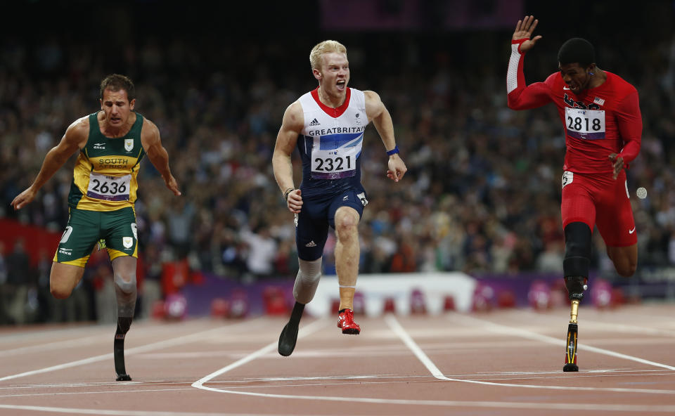 Britain's Jonnie Peacock (C) wins the men's 100m T-44 final ahead of South Africa's Amu Fourie (L) and Richard Browne of the U.S. in the Olympic Stadium at the London 2012 Paralympic Games September 6, 2012. REUTERS/Suzanne Plunkett (BRITAIN - Tags: SPORT OLYMPICS ATHLETICS)