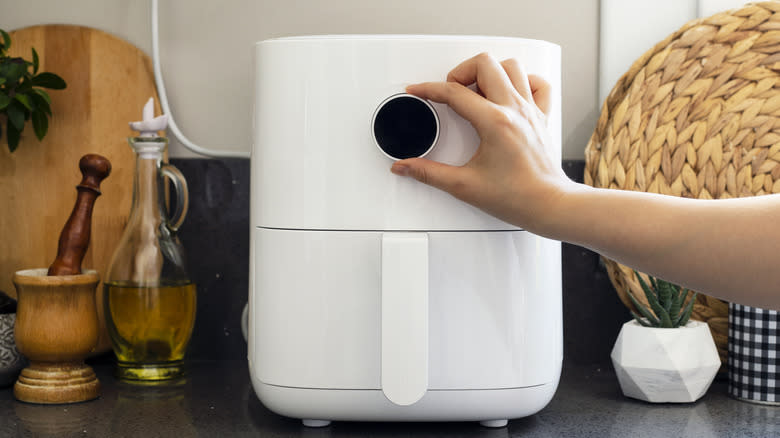 Person programming an air fryer