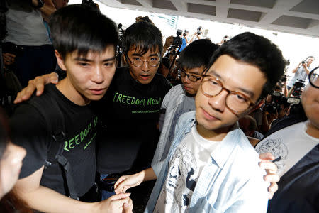 Student leaders Lester Shum, Alex Chow, Joshua Wong and Nathan Law hold hands as they walk into the High Court to face verdict on charges relating to the 2014 pro-democracy Umbrella Movement, also known as Occupy Central protests, in Hong Kong, China August 17, 2017. REUTERS/Tyrone Siu
