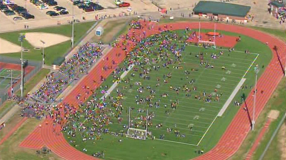 In this image from video provided by KHOU, students evacuated from Seven Lakes High School in Katy, Texas, mingle on the football field on Monday Jan. 13, 2014 after officials say a "potential explosive device" was identified in the building. After a bomb squad was dispatched, a student is in custody. (AP Photo/KHOU)