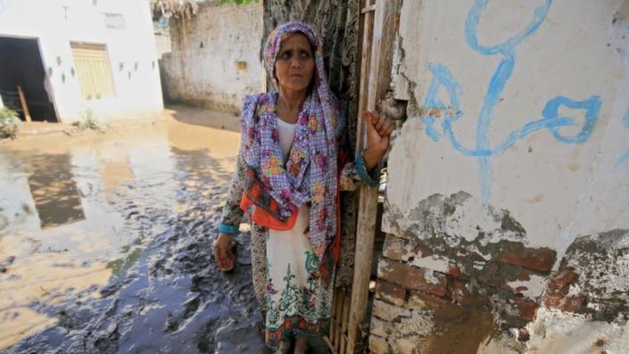 A woman stands outside her house in Charsadda district, Khyber Pakhtunkhwa province on August 28