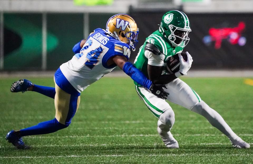 Saskatchewan Roughriders receiver Ajou Ajou runs the football as Winnipeg Blue Bombers defensive back Terrell Bonds during the second half.