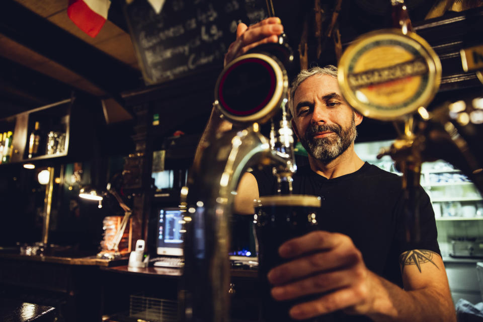 A bartender pouring a beer