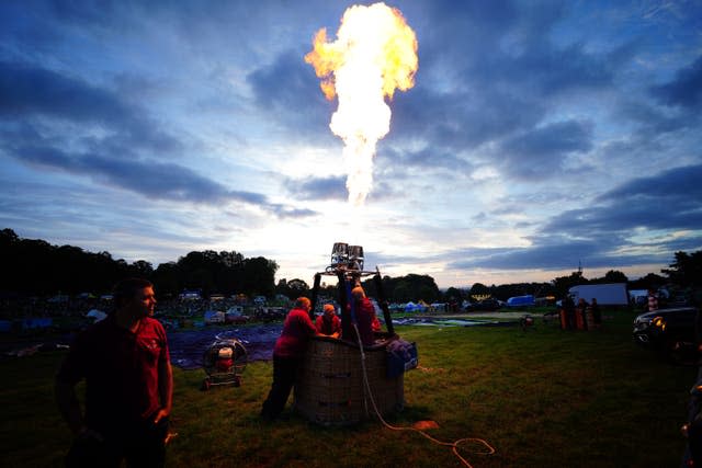 A balloonist tests his burner ahead of Friday morning's mass ascent (Ben Birchall/PA)