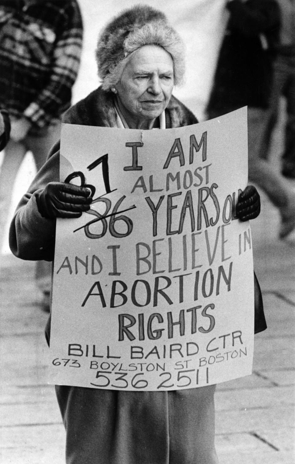 A protester holds a sign reading "I am almost 87 years old and I believe in abortion rights"