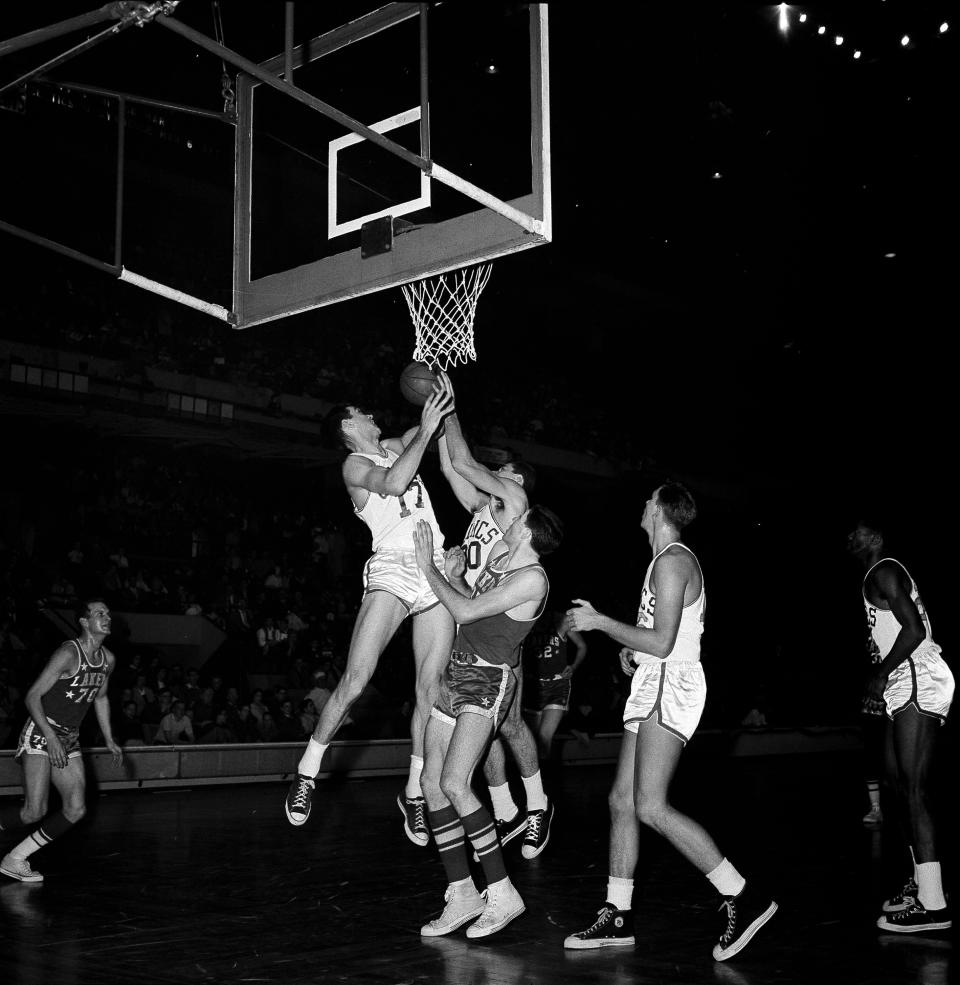 Gene Conley, left, of the Boston Celtics snags a rebound from the reach of teammate Gene Guarilia as Rudy LaRusseo of the <a class="link " href="https://sports.yahoo.com/nba/teams/la-lakers/" data-i13n="sec:content-canvas;subsec:anchor_text;elm:context_link" data-ylk="slk:Minneapolis Lakers;sec:content-canvas;subsec:anchor_text;elm:context_link;itc:0">Minneapolis Lakers</a> moves out of the way in their NBA game at the Boston Garden, Feb. 26, 1960. Watching action at right is John Richter of the Celtics. Celts won the game, 128-111. (AP Photo/Peter J. Carroll)