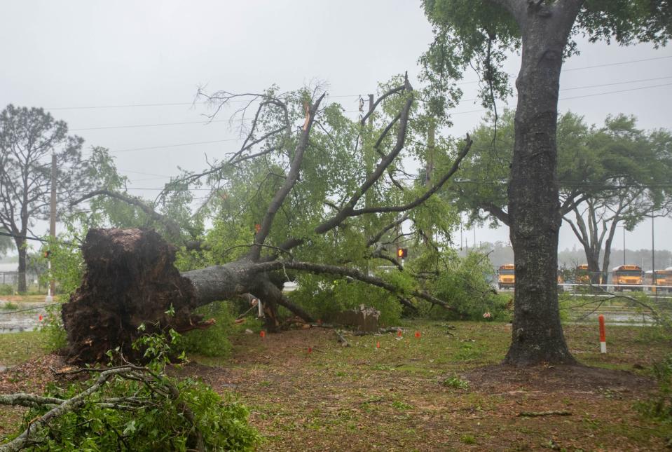 Traffic lights, utility lines and debris cover the street at the intersection of Longleaf and Community Drives as a storm passes through the Pensacola area on Wednesday, April 10, 2024.