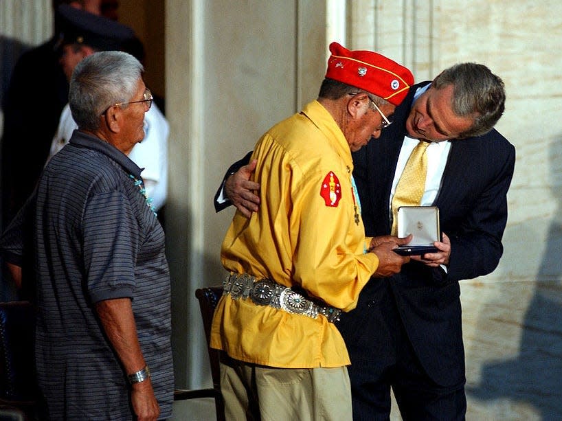 President George W. Bush presents the Gold Medal to John Brown, Jr., Navajo Code Talker, during the Gold Medal Ceremony in the U.S. Capitol. To the left is Navajo Code Talker and Gold Medal winner Chester Nez.