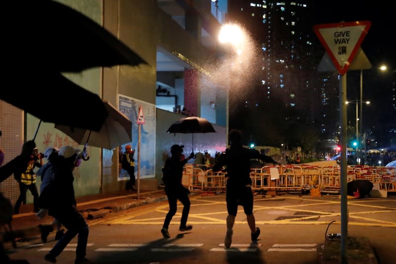 An anti-government protester throws a Molotov cocktail during a protest, following 22 year-old University student's fall and who was critically injured last weekend, in Tseung Kwan O, Hong Kong